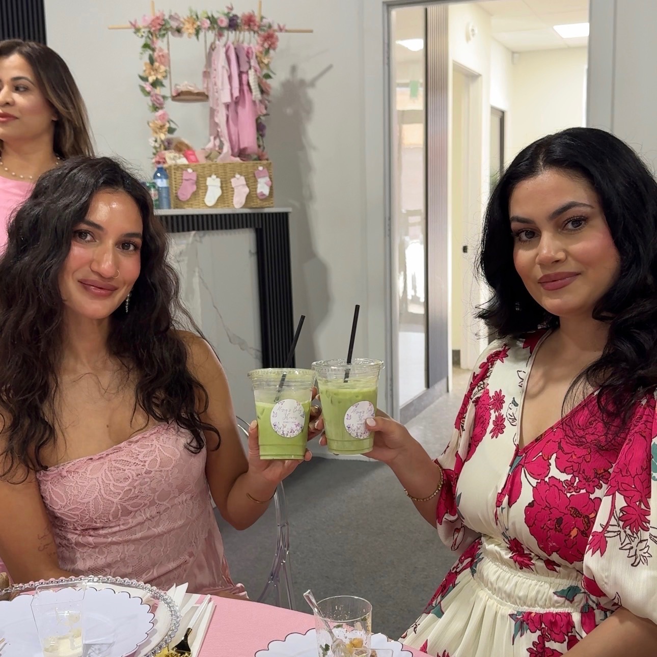 Guests cheersing iced matcha lattes at a baby shower