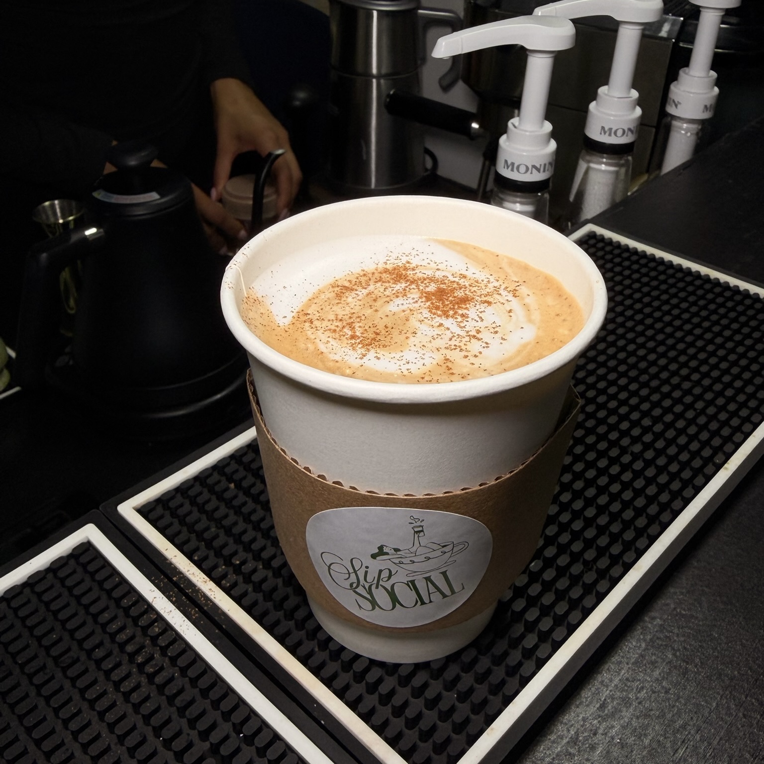 Fresh hot latte with cinnamon dusting at the Sip Social bar
